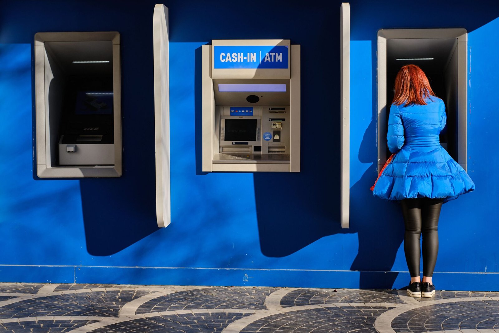 A lady is withdrawing money from ATM