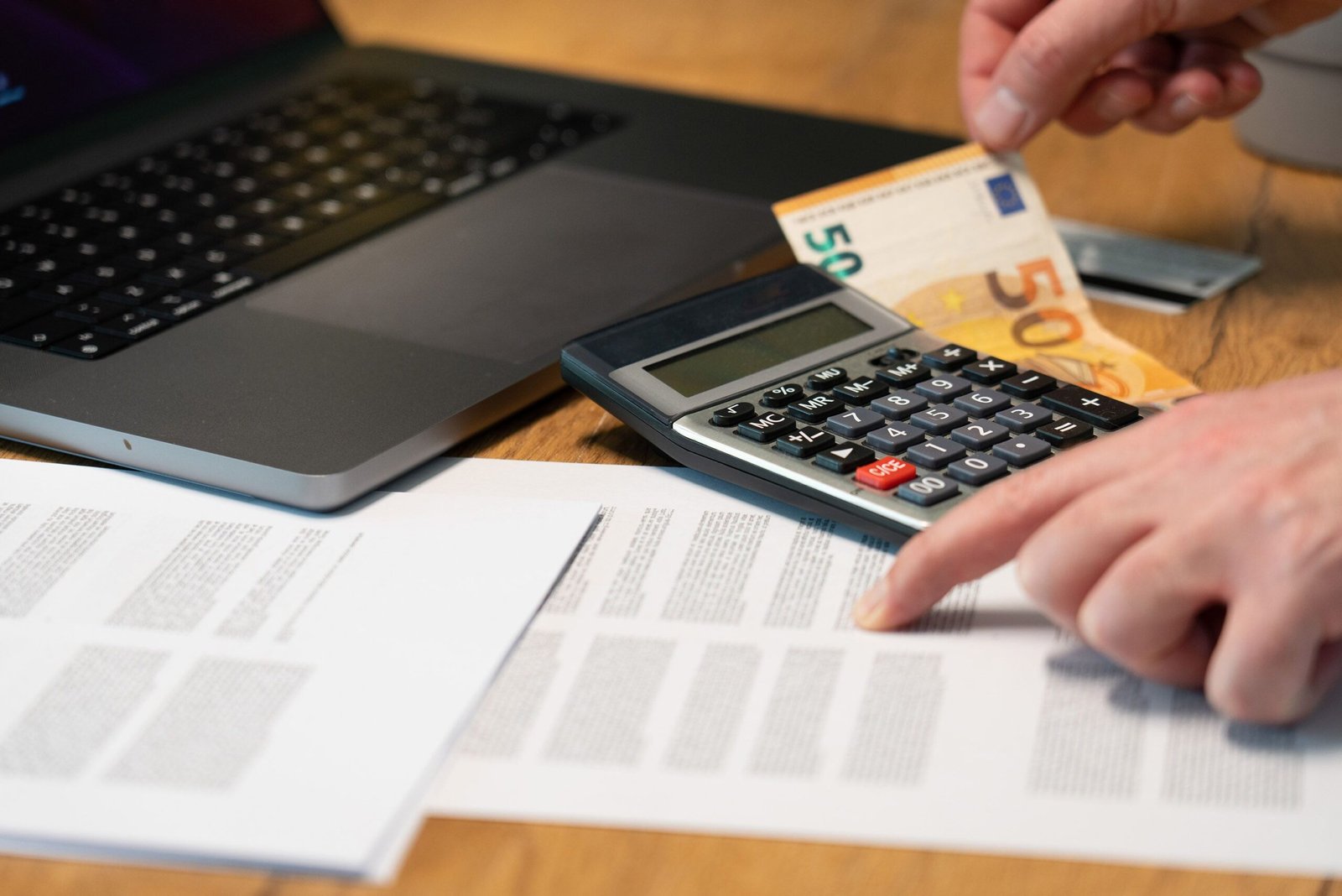A person is calculating debt with calculator
