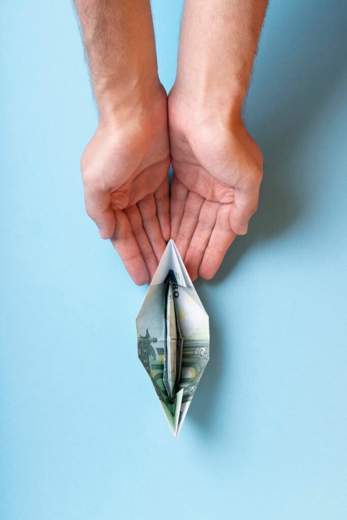 Open hands receiving folded banknote, representing emergency funds for urgent expenses