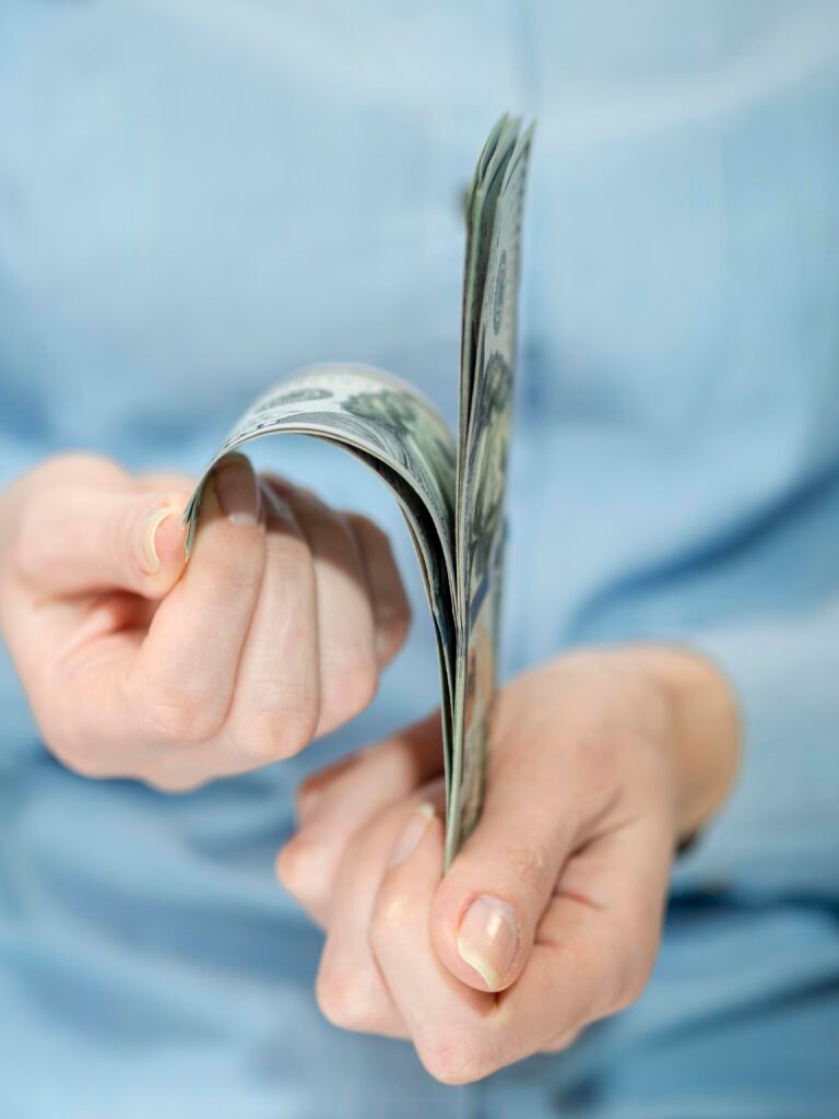 Person counting cash while planning how much emergency loan to borrow